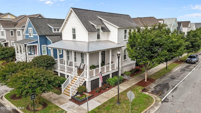 view of front of house featuring a porch, a residential view, roof with shingles, and stairs