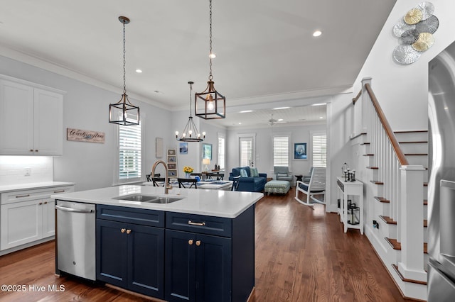 kitchen with a sink, appliances with stainless steel finishes, light countertops, white cabinets, and ornamental molding