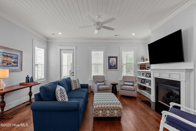 living room featuring ornamental molding, a ceiling fan, a fireplace, wood ceiling, and dark wood-type flooring