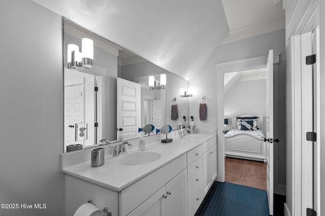 full bath with ensuite bath, double vanity, crown molding, and wood finished floors