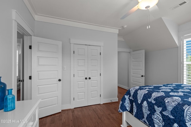 bedroom featuring dark wood-type flooring, a closet, lofted ceiling, baseboards, and a ceiling fan