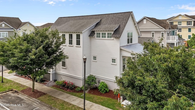 view of side of property with a shingled roof and a residential view
