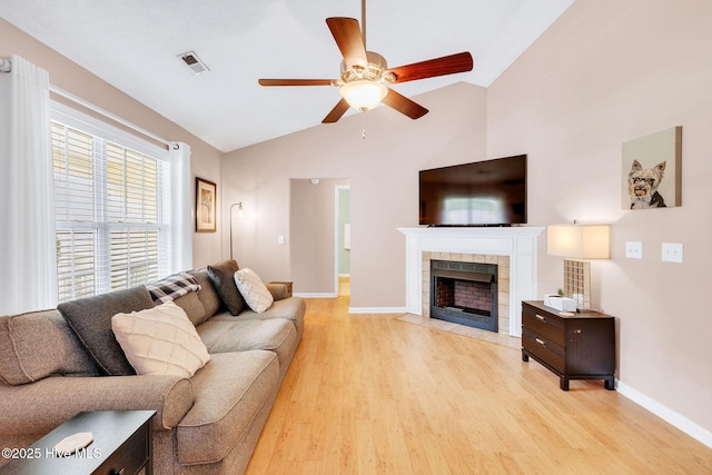 7394 Red Stone Ct, Leland, NC 28451 - living area with vaulted ceiling, light wood finished floors, a ceiling fan, baseboards, and a tile fireplace