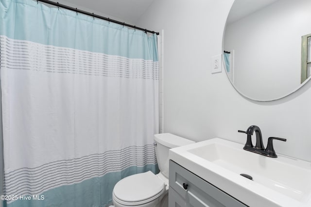 bathroom featuring toilet, vanity, and curtained shower