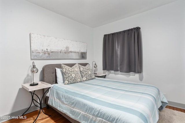 bedroom with wood finished floors and baseboards