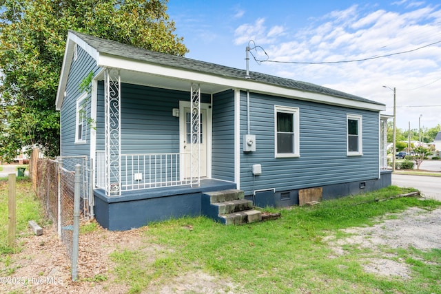 view of front of house with crawl space, fence, and a porch