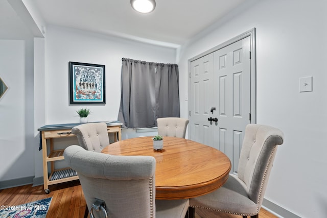 dining space featuring wood finished floors and baseboards