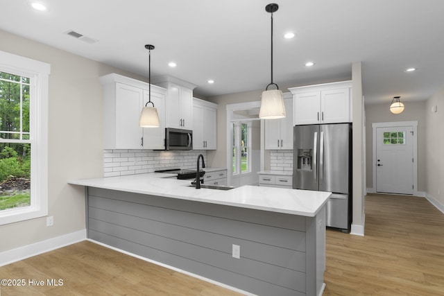 kitchen with stainless steel refrigerator with ice dispenser, a peninsula, backsplash, baseboards, and white cabinets