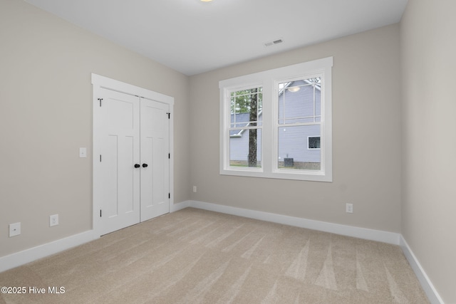 unfurnished bedroom with carpet flooring, baseboards, and a closet