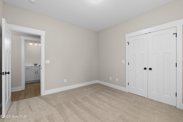 unfurnished bedroom featuring carpet, baseboards, and a closet