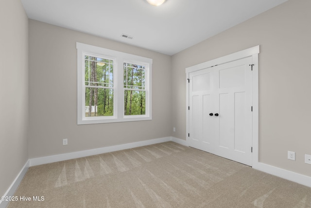 unfurnished bedroom featuring carpet floors, baseboards, and a closet