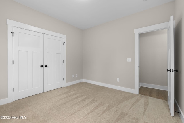 unfurnished bedroom featuring carpet flooring, baseboards, and a closet
