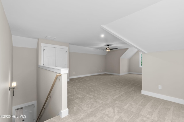 bonus room with light colored carpet, vaulted ceiling, baseboards, and a ceiling fan