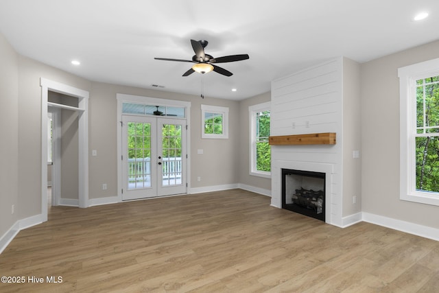 unfurnished living room with light wood-style flooring, a fireplace, ceiling fan, baseboards, and recessed lighting
