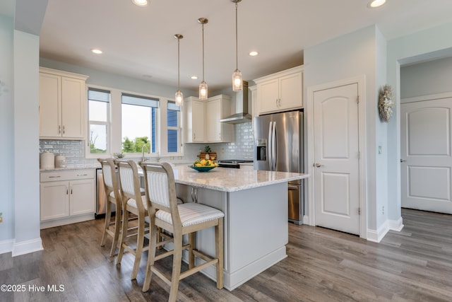 145 Whispering Pine Ln, Holly Ridge, NC 28445 - kitchen with stainless steel refrigerator with ice dispenser, wall chimney exhaust hood, a kitchen island, wood finished floors, and recessed lighting
