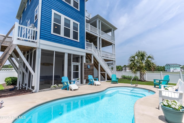 145 Whispering Pine Ln, Holly Ridge, NC 28445 - rear view of property with stairs, a balcony, a patio area, a fenced backyard, and a sunroom