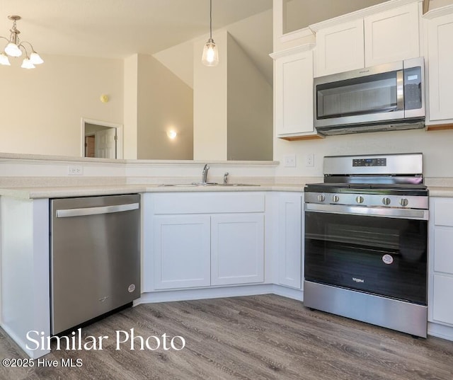 128 Buckskin Dr, Pollocksville, NC 28573 - kitchen with stainless steel appliances, wood finished floors, light countertops, white cabinets, and pendant lighting