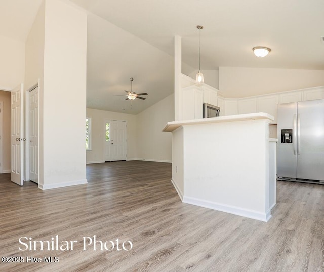 128 Buckskin Dr, Pollocksville, NC 28573 - kitchen with stainless steel refrigerator with ice dispenser, light wood-type flooring, high vaulted ceiling, and white cabinets