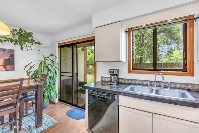 kitchen with dishwasher, a sink, tile counters, and white cabinetry