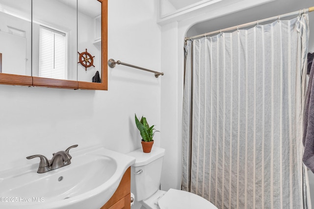 bathroom with toilet, vanity, and a shower with curtain