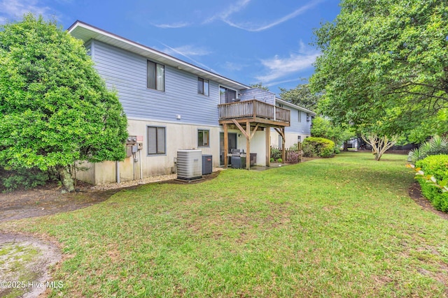 rear view of house featuring a yard, a wooden deck, and cooling unit