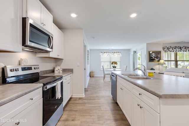 kitchen featuring stainless steel appliances, light wood-style floors, white cabinets, light countertops, and recessed lighting