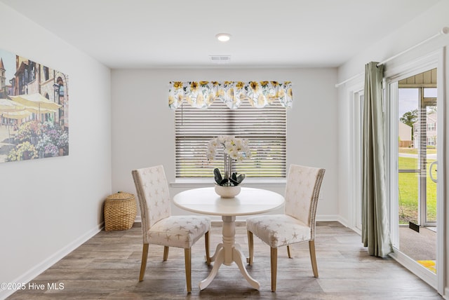 dining room featuring healthy amount of natural light, light wood-style floors, and baseboards