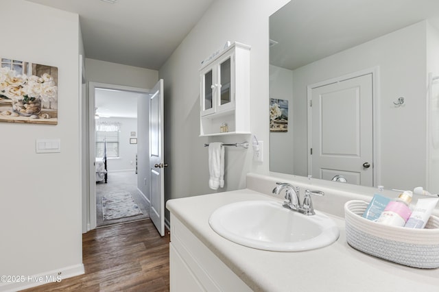 bathroom featuring wood finished floors, baseboards, and vanity
