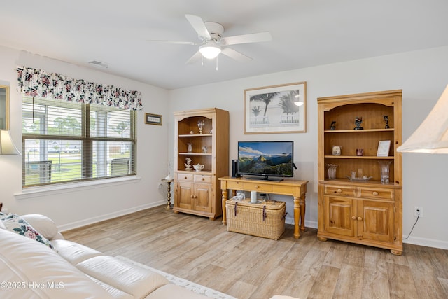 living room featuring a ceiling fan, light wood-style floors, and baseboards