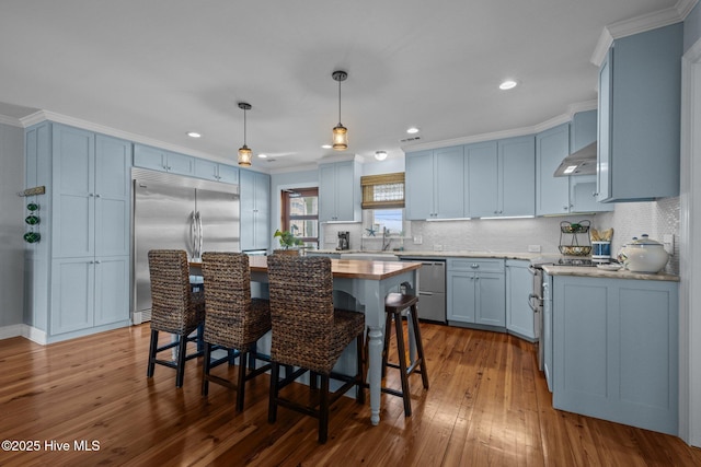 141 Bayview Blvd, Atlantic Beach, NC 28512 - kitchen with stainless steel appliances, blue cabinetry, ornamental molding, under cabinet range hood, and a sink