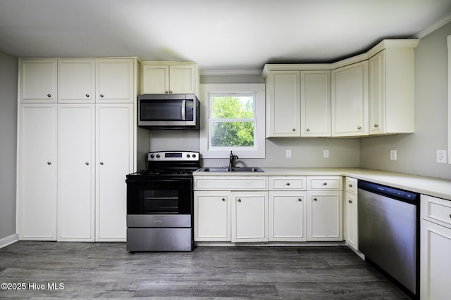 808 Green St, New Bern, NC 28560 - kitchen with stainless steel appliances, a sink, ornamental molding, cream cabinets, and light countertops