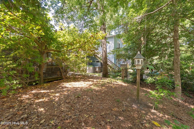 view of yard featuring a wooden deck and stairway