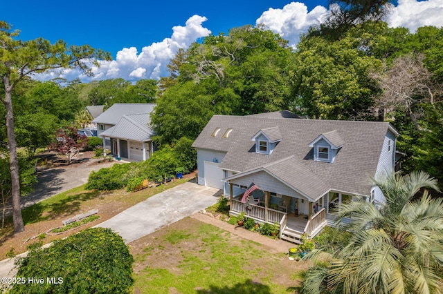 aerial view of property and surrounding area featuring a tree filled landscape