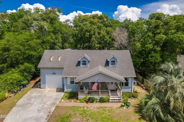 cape cod-style house with a porch, an attached garage, concrete driveway, and roof with shingles