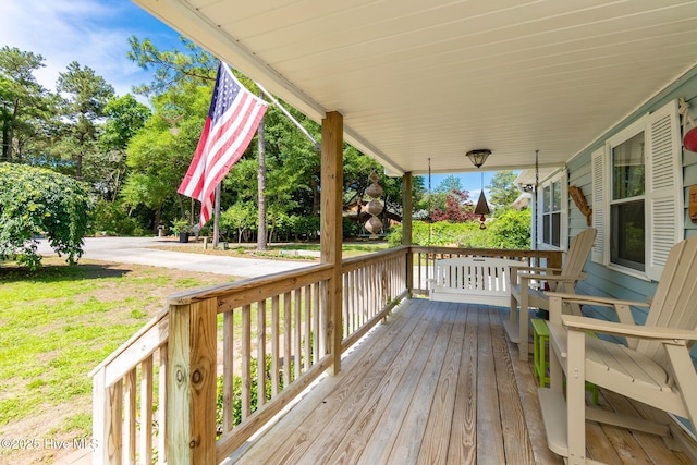 deck with covered porch and a yard