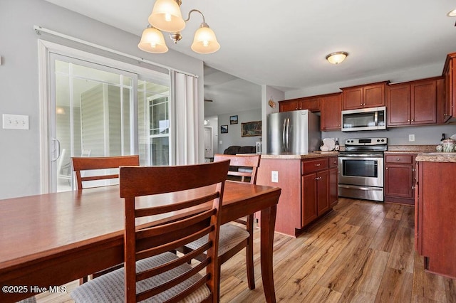 312 Hughes Ln, Jacksonville, NC 28546 - kitchen featuring appliances with stainless steel finishes, light wood-type flooring, a center island, pendant lighting, and light countertops