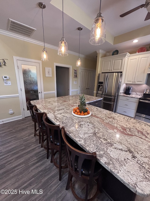 201 Shreveport Ct, Havelock, NC 28532 - kitchen featuring appliances with stainless steel finishes, dark wood-style flooring, light stone countertops, white cabinetry, and ornamental molding