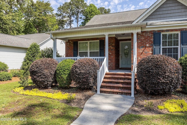903 Buckingham Rd, Trent Woods, NC 28562 - view of front of house featuring brick siding, covered porch, and a shingled roof