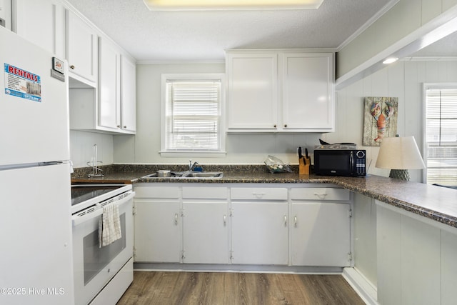 kitchen featuring white appliances, a sink, dark wood-style floors, white cabinetry, and ornamental molding