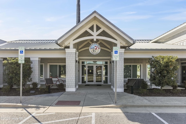 property entrance featuring a standing seam roof, metal roof, and french doors