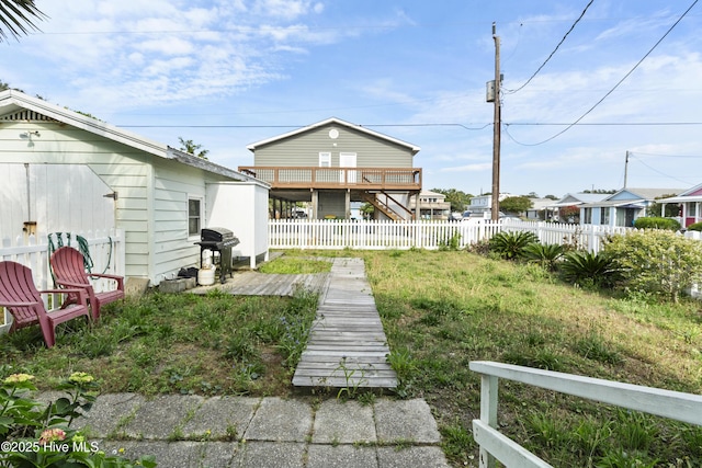 rear view of property with a fenced backyard and a wooden deck