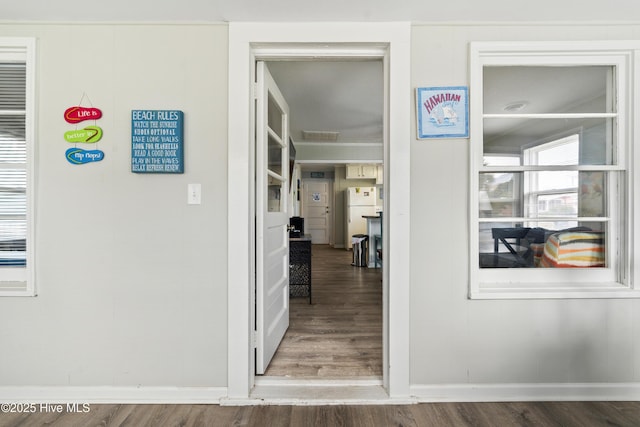 hallway with wood finished floors and baseboards