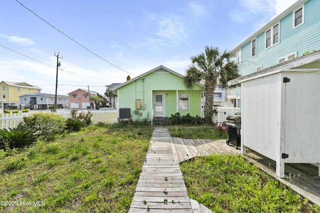 rear view of house with fence, cooling unit, a residential view, and a wooden deck