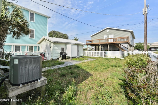 rear view of house featuring central AC unit, an outdoor structure, and a fenced backyard