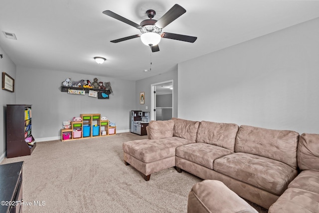 living area featuring carpet floors, baseboards, and a ceiling fan
