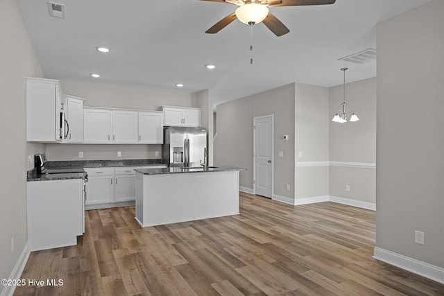 kitchen with appliances with stainless steel finishes, a ceiling fan, wood finished floors, a sink, and recessed lighting