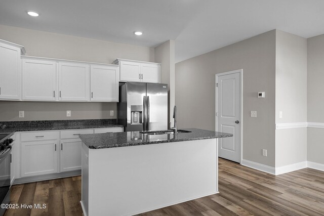 kitchen with stainless steel fridge with ice dispenser, a sink, dark stone counters, white cabinetry, and dark wood finished floors