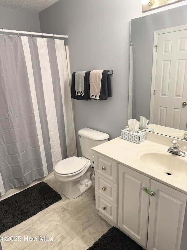 full bath with toilet, vanity, a shower with shower curtain, and a textured ceiling
