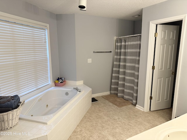 bathroom with a textured ceiling, a tub with jets, a sink, a shower with curtain, and baseboards