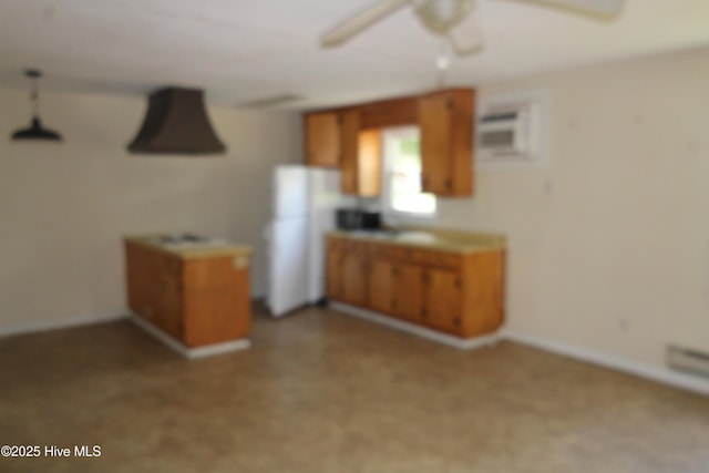 kitchen featuring ceiling fan, brown cabinetry, and baseboards